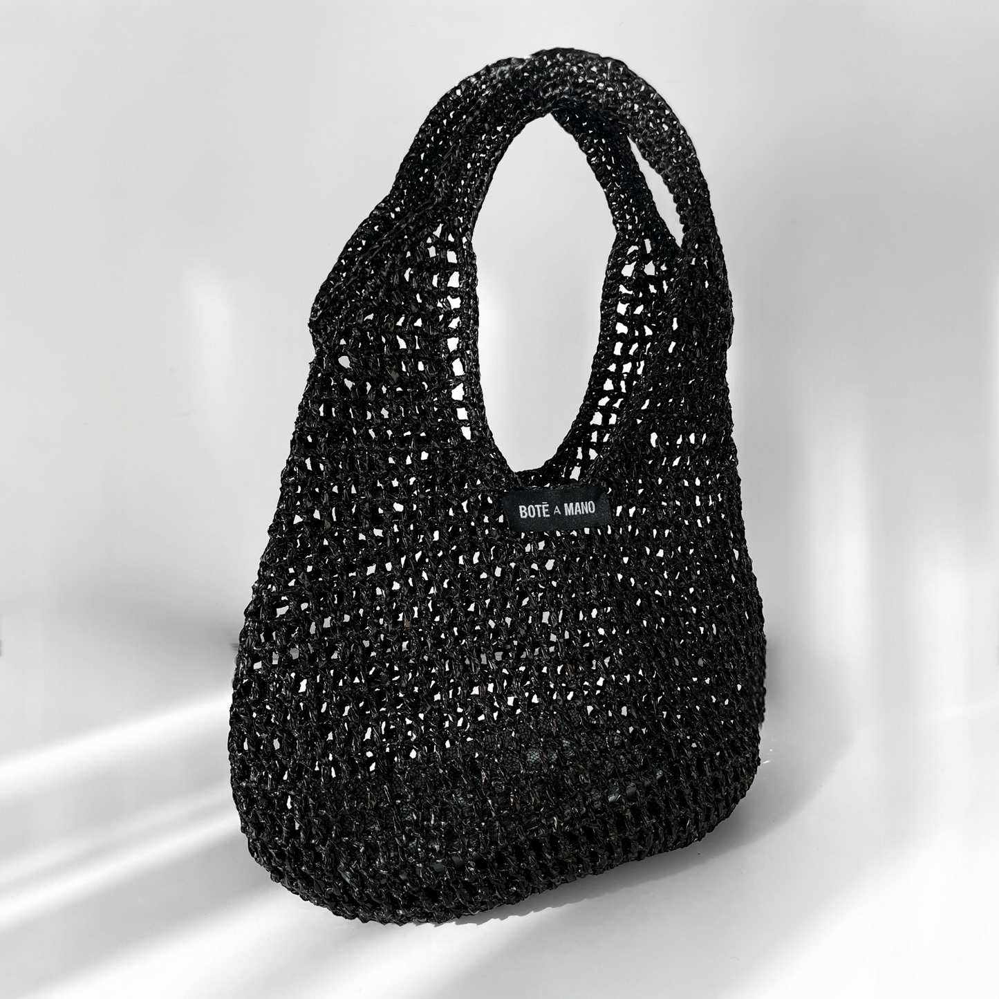 Handwoven black raffia top handle bag by Bote A Mano — a luxury, all-season accessory with artisanal detailing