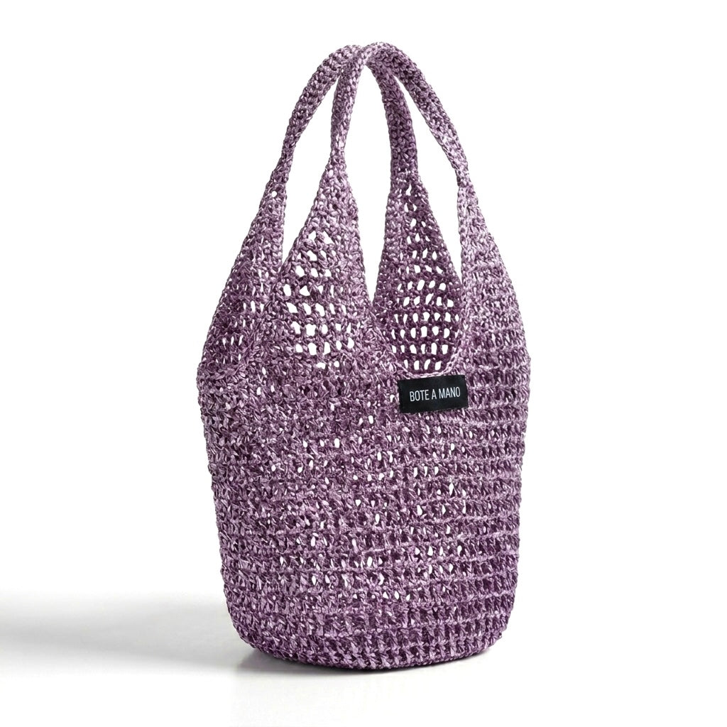 Side view of lilac raffia bag showing flexible structure and metallic woven finish by Bote A Mano.