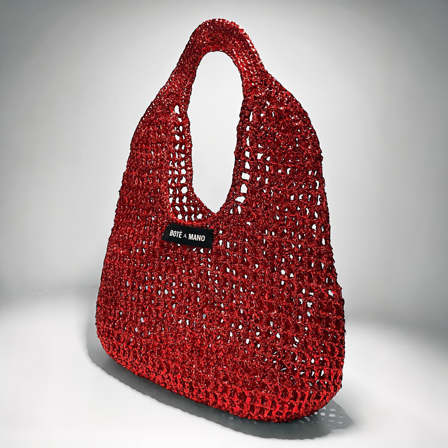 Side profile of the structured Burgundy raffia top handle handbag as a chic red fall accessory, highlighting its silhouette.