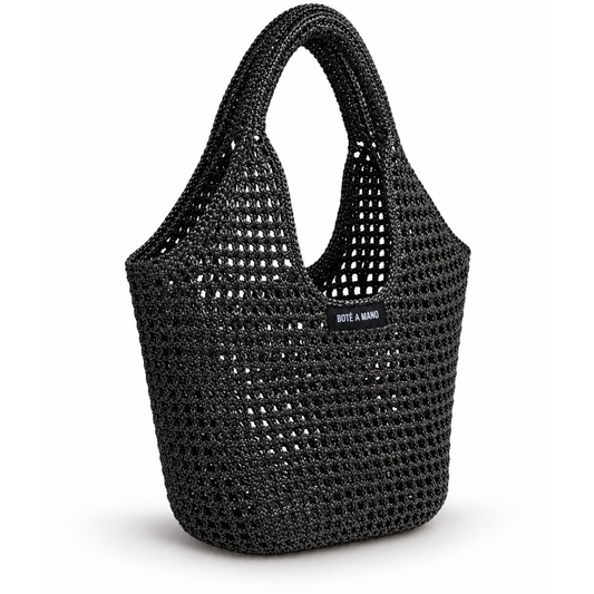 Side view of black raffia bag showing flexible structure and artisanal woven craftsmanship by Bote A Mano