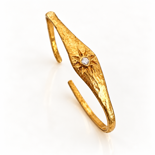 Close-up of crystal sunburst motif on Bote A Mano 24K gold-plated bracelet