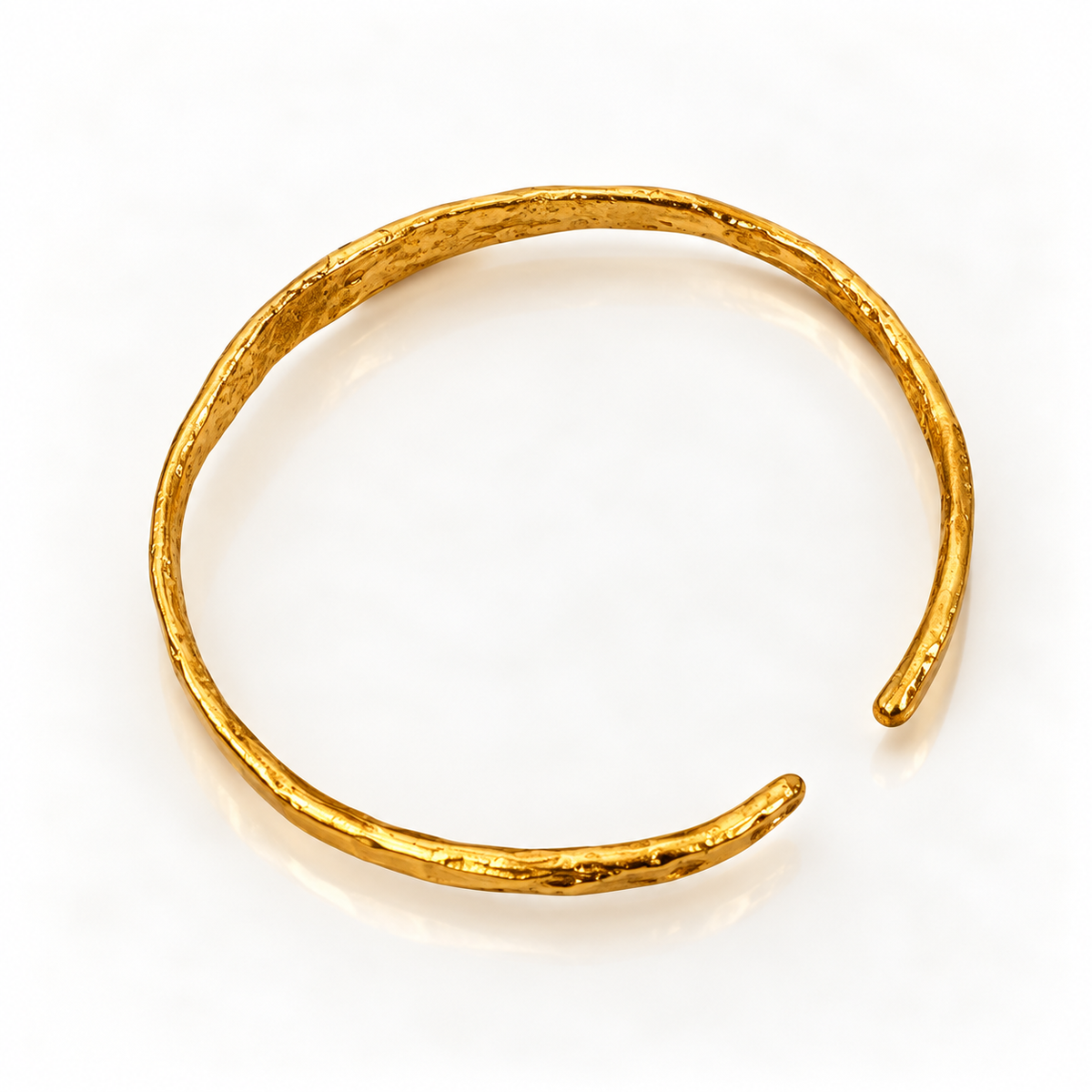 A textured gold open cuff bangle bracelet on a clean white background.