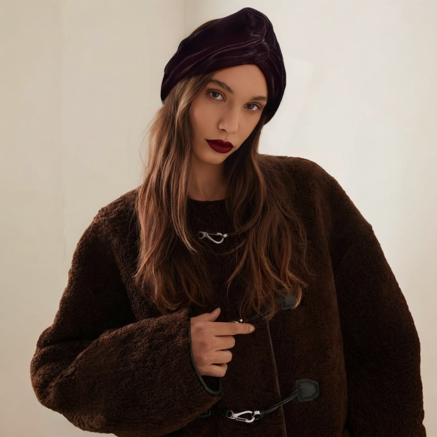 Woman wearing a BOTE A MANO wide burgundy velvet headband worn over the head like an elegant Italian turban.