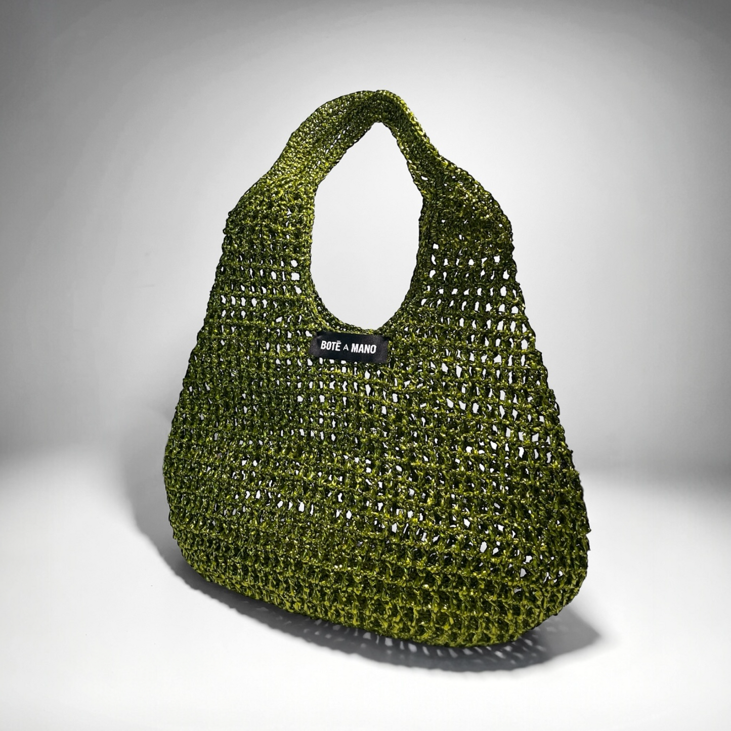 Full view of the dark green bucket bag showing the full size, drawstring top closure, and elegant seasonal silhouette.