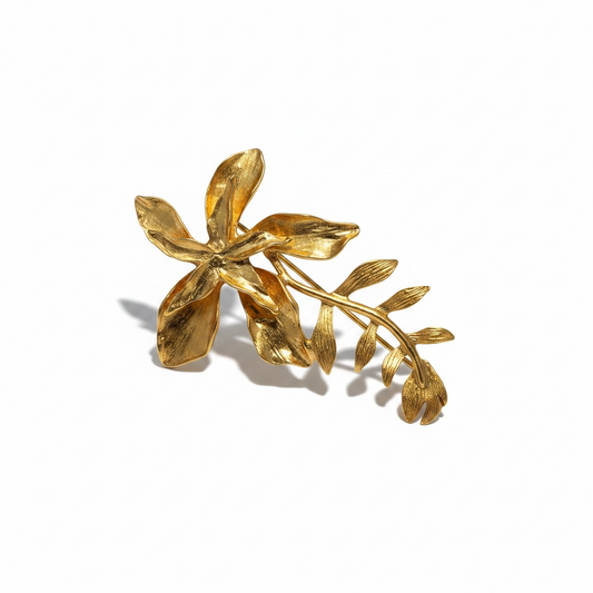 Front view of gold floral brooch by Bote A Mano, 24K gold-plated with sculptural petals and leaf design.