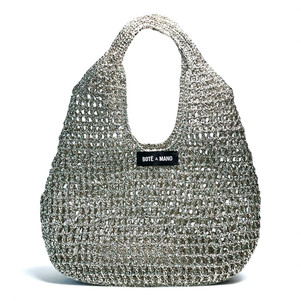 Close-up of the shimmering metallic raffia weave and the hardware of the silver bucket bag, emphasizing the Italian-made quality.