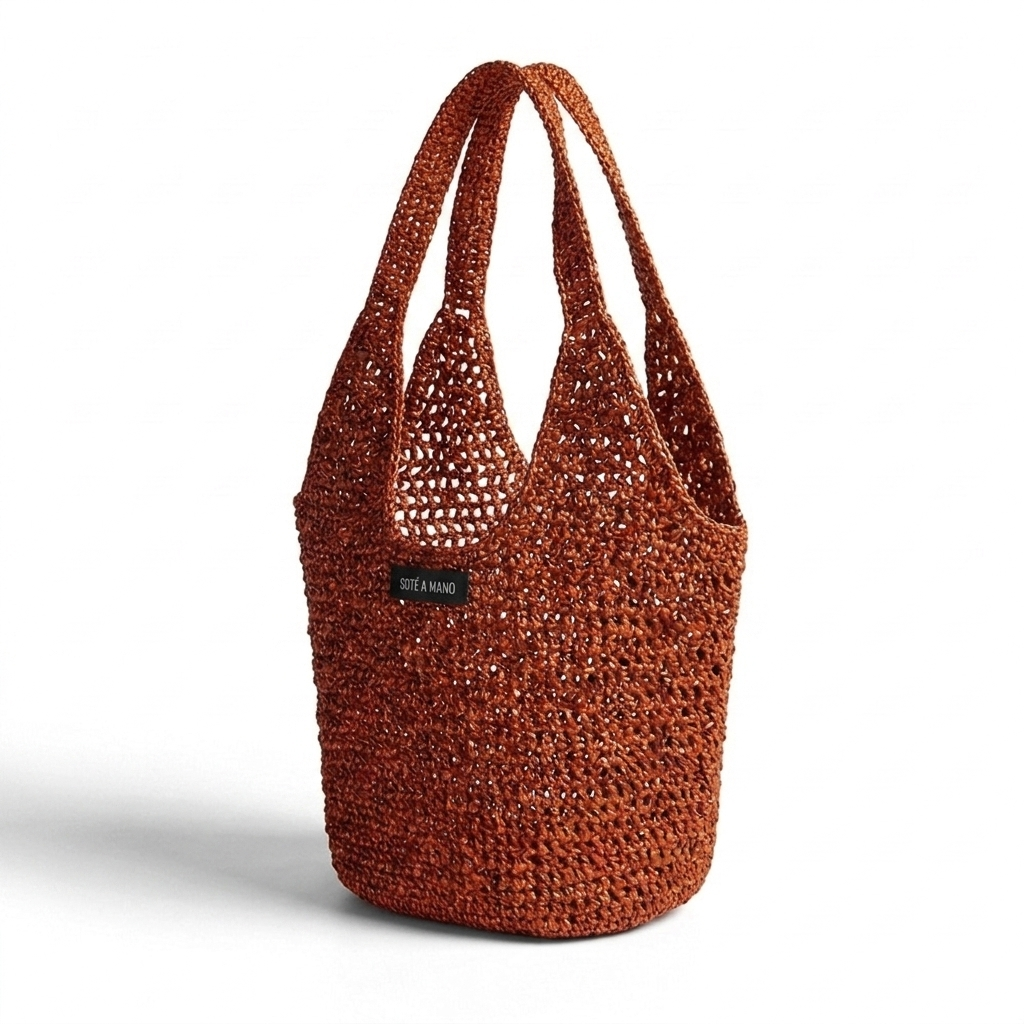 Side view of orange copper raffia bag showing metallic woven texture and artisanal craftsmanship by Bote A Mano
