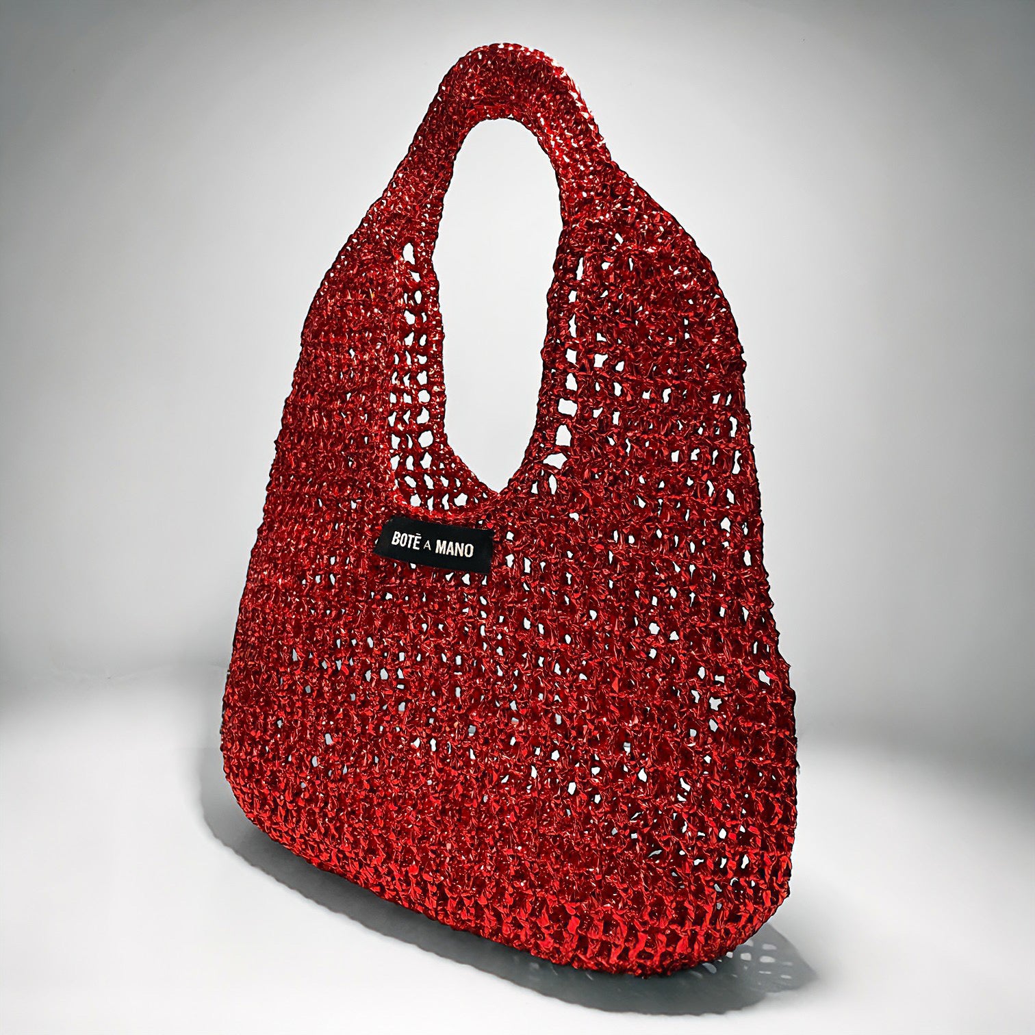 Side profile of the structured Burgundy raffia top handle handbag as a chic red fall accessory, highlighting its silhouette.