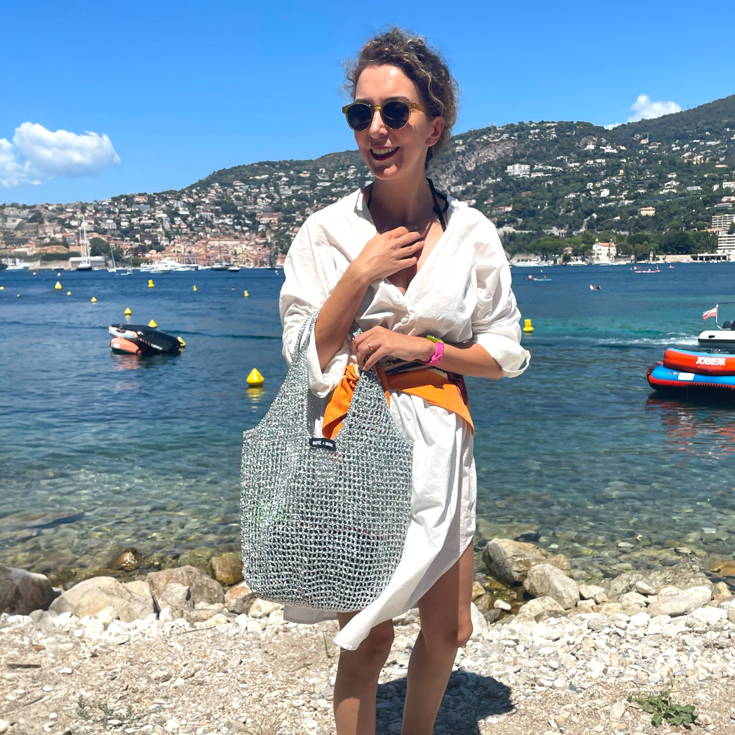 Model carrying silver metallic raffia bag by Bote A Mano in an elegant lifestyle setting
